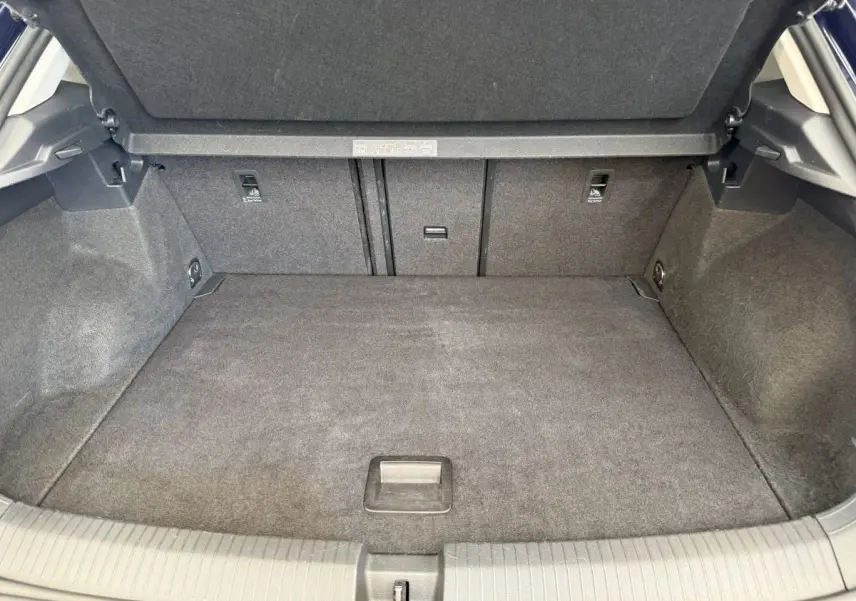 Coffre spacieux et propre du Volkswagen T-Roc bleu, vue intérieure arrière avec banquette rabattue et plancher plat.