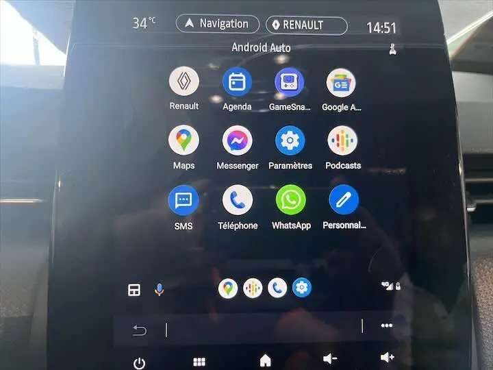Écran tactile central de la Renault Clio V blanc nacré, affichant l'interface Android Auto avec plusieurs applications.