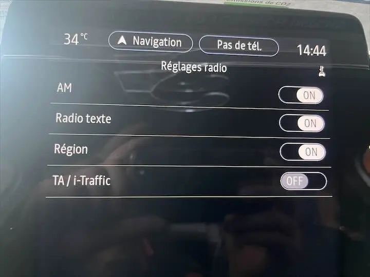 Écran tactile de la Renault Clio V blanc nacré montrant les réglages radio avec options activées et désactivées.
