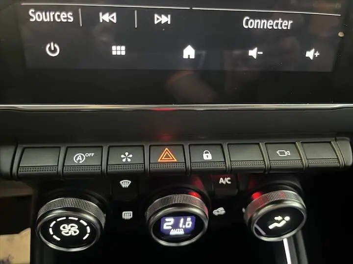 Gros plan sur la console centrale de la Renault Clio V avec commandes climatisation et écran tactile affichant 21,6°C.