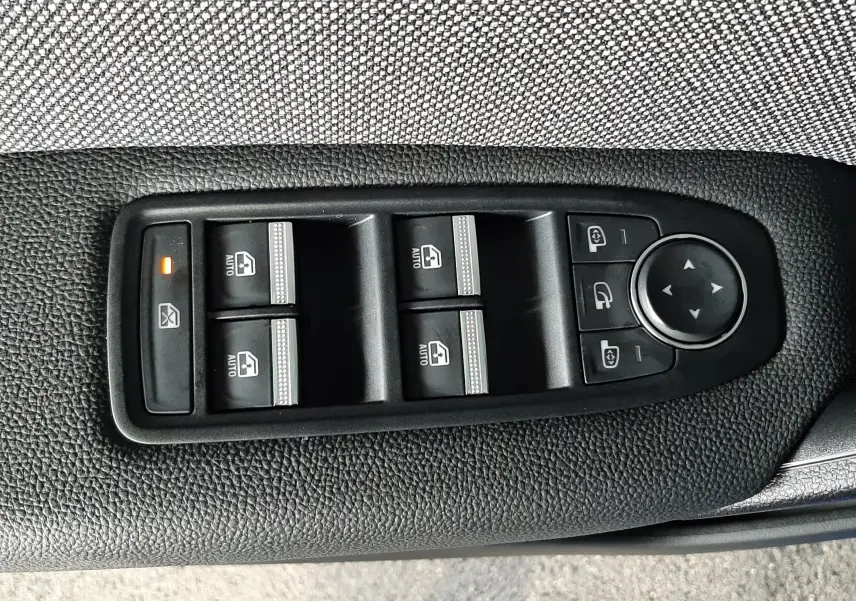 Panneau de commandes des vitres et rétroviseurs sur la porte côté conducteur d'un Renault Captur bleu iron 2024.