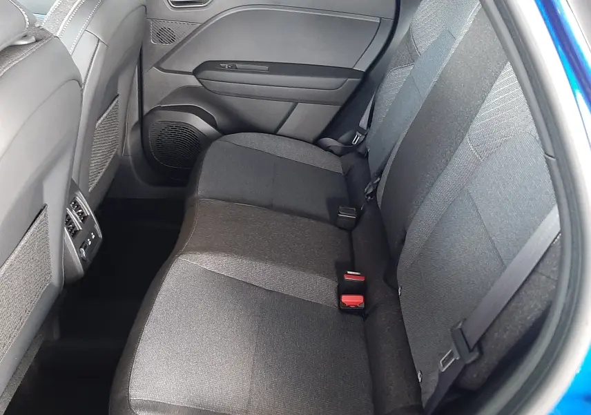 Vue intérieure côté droit des sièges arrière en tissu gris du Renault Captur E-Tech Hybrid 2024 bleu iron avec toit noir.