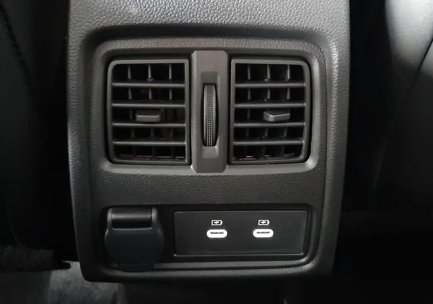 Vue rapprochée des aérateurs arrière et des ports USB du Renault Captur E-Tech Hybrid 2024 avec intérieur noir.