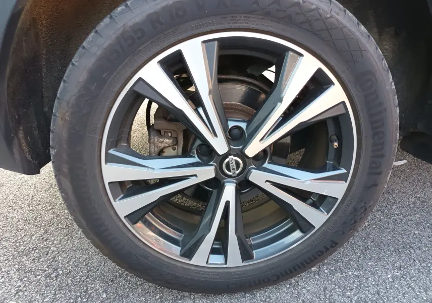 Gros plan sur la jante bi-ton noir et argent d'un Nissan Qashqai blanc nacré de 2019 avec pneu Continental.