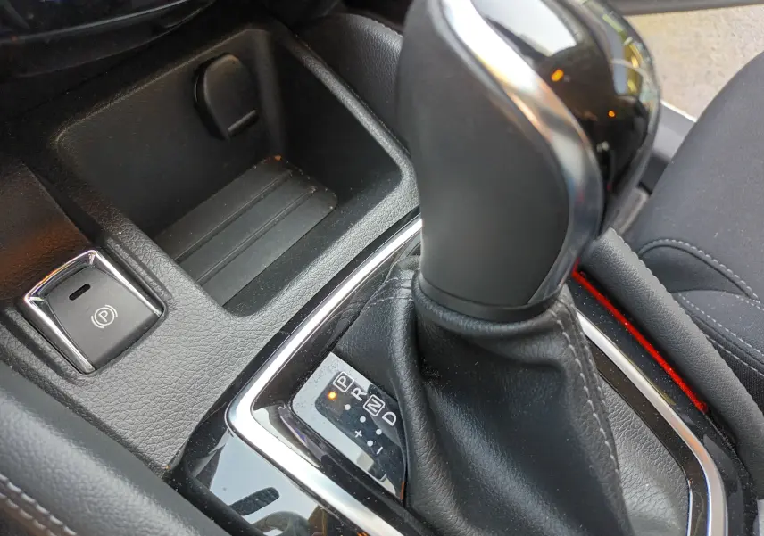 Gros plan sur le levier de vitesse automatique et le frein à main électrique du Nissan Qashqai blanc nacré 2019.