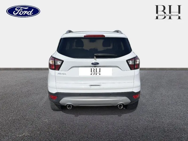 Vue arrière d'un Ford Kuga blanc glacier 2017 avec hayon motorisé et double sortie d'échappement visible.