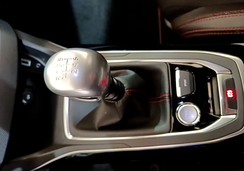 Gros plan sur levier de vitesses manuel gris argenté et console centrale noire avec surpiqûres rouges dans Peugeot 308 GT Line 2016.