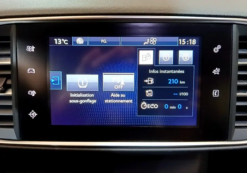 Écran tactile central de la Peugeot 308 gris foncé affichant l'aide au stationnement et l'initialisation sous-gonflage