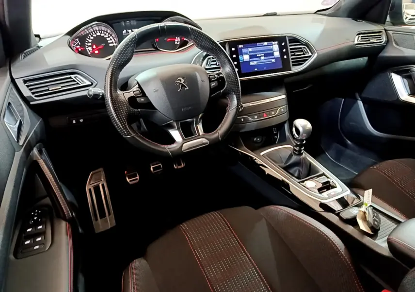 Intérieur de la Peugeot 308 GT Line 2016, vue du poste de conduite avec volant cuir et écran tactile central.
