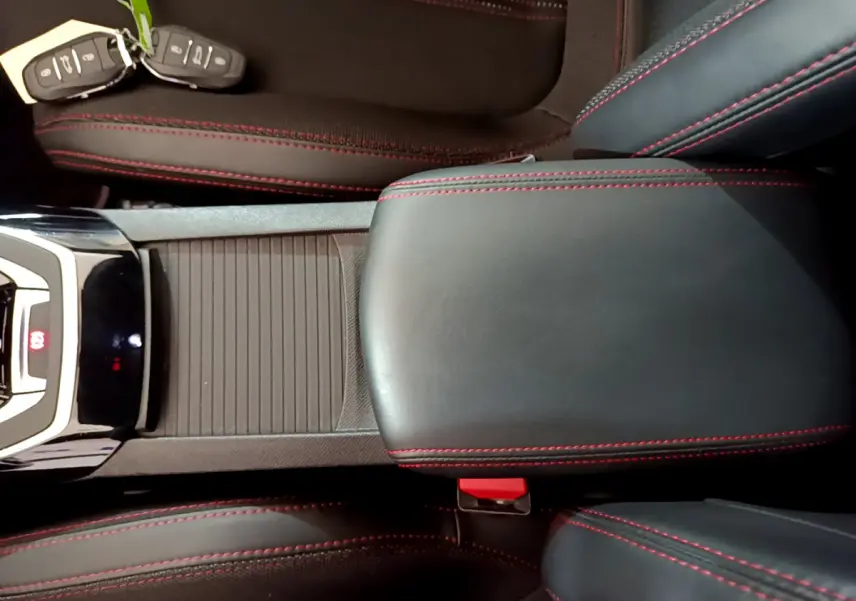 Vue rapprochée de la console centrale et accoudoir en cuir noir avec surpiqûres rouges d'une Peugeot 308 GT Line 2016.