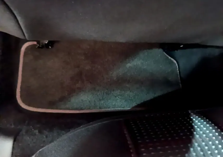 Tapis de sol noir avec surpiqûres rouges côté passager arrière d'une Peugeot 308 gris foncé 2016.