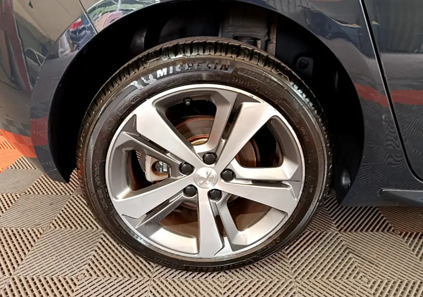 Gros plan sur la roue avant gauche gris foncé d'une Peugeot 308 1.2 PureTech 130 S&S GT Line de 2016 avec jante alliage.