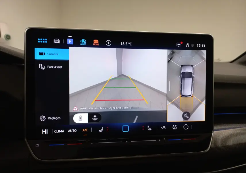 Écran du système d'infodivertissement affichant la caméra 360° avec vue arrière et vue aérienne d'une Volkswagen Golf gris lunaire.