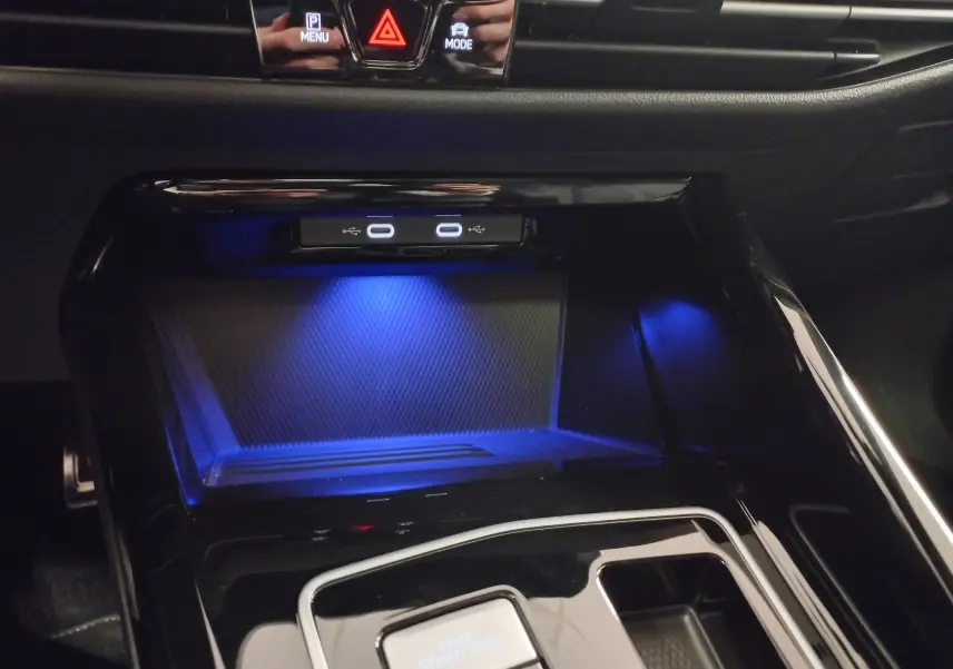 Gros plan sur la console centrale noire avec éclairage bleu et ports USB de la Volkswagen Golf 2.0 TDI 2026.