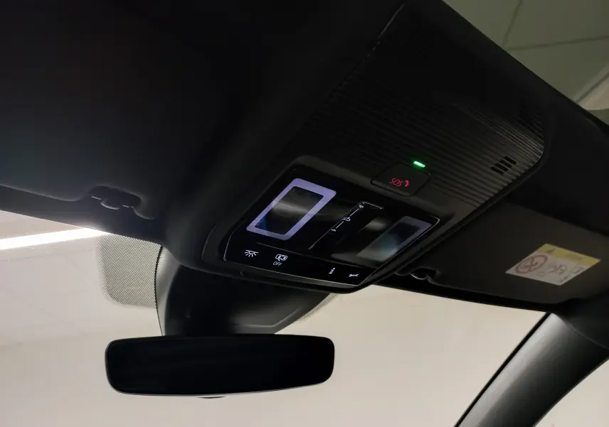 Vue intérieure du toit ouvrant panoramique avec commandes lumineuses et bouton SOS du Volkswagen Golf gris lunaire 2026.