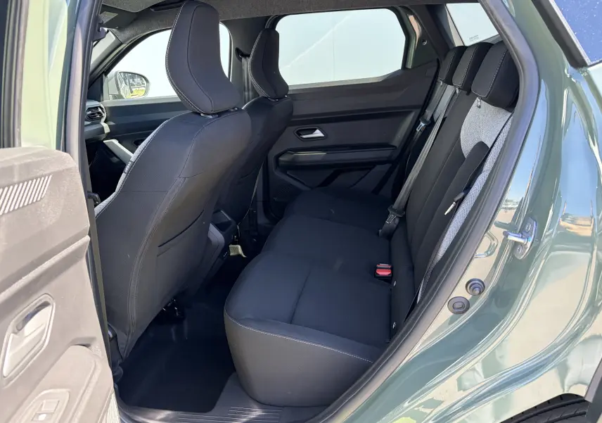 Vue côté droit arrière du Dacia Duster III 2026 kaki lichen, montrant les sièges arrière en tissu noir avec appuie-têtes.