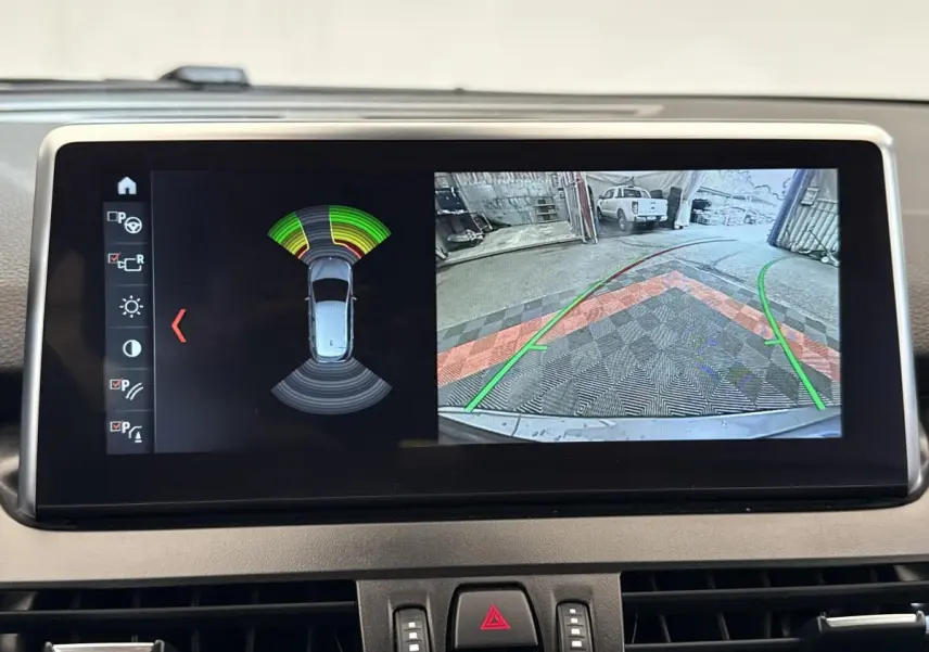 Écran tactile intérieur montrant l’aide au stationnement et la caméra de recul de la BMW Série 2 Active Tourer gris foncé.