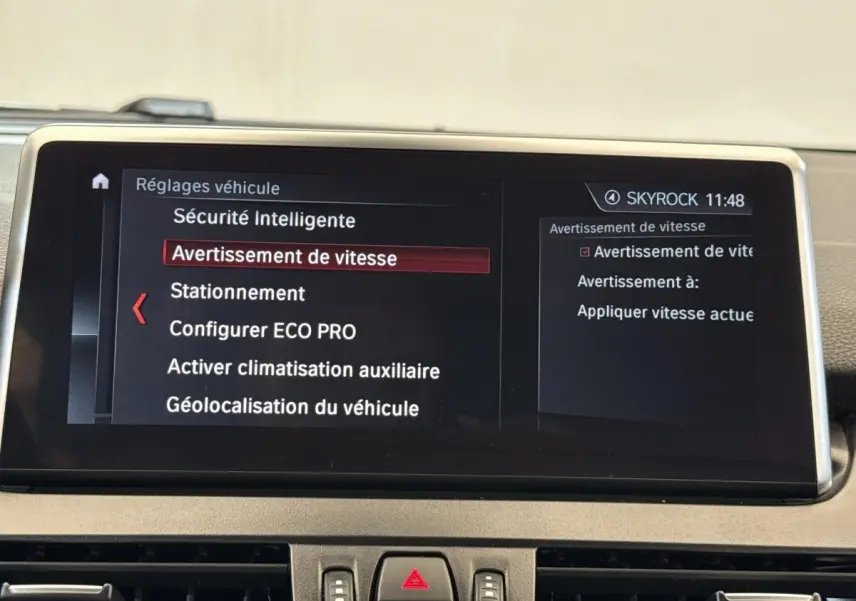 Écran tactile intérieur de BMW Série 2 Active Tourer 225xe gris foncé affichant les réglages de sécurité et vitesse.
