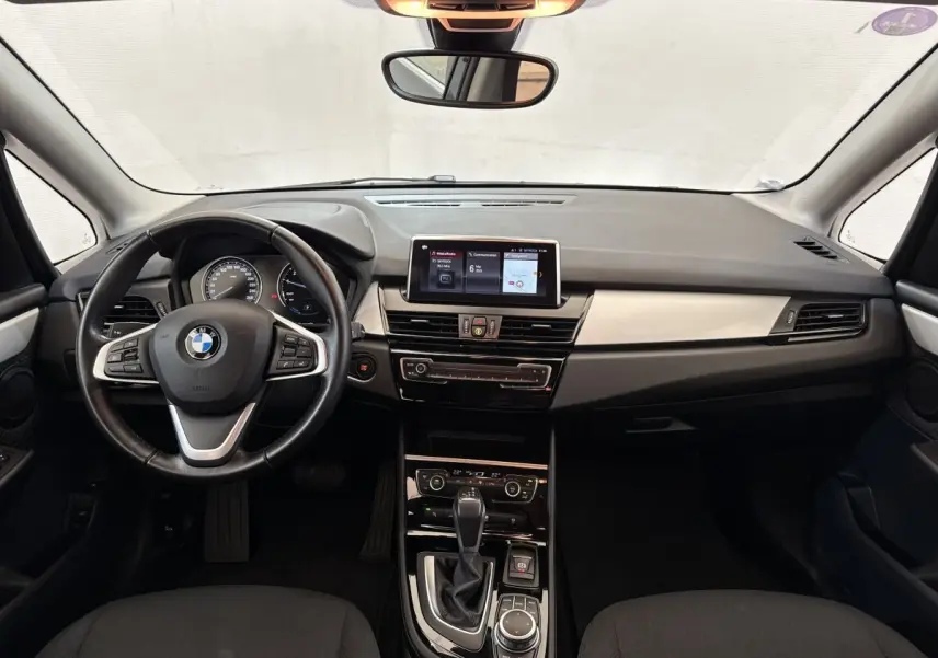 Vue frontale de l'intérieur gris foncé du BMW Série 2 Active Tourer 225xe avec tableau de bord et écran tactile central.