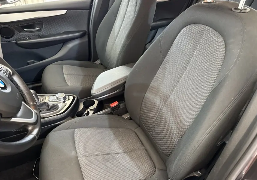 Vue intérieure côté conducteur de la BMW Série 2 Active Tourer 225xe gris foncé, montrant les sièges tissu et la console centrale.