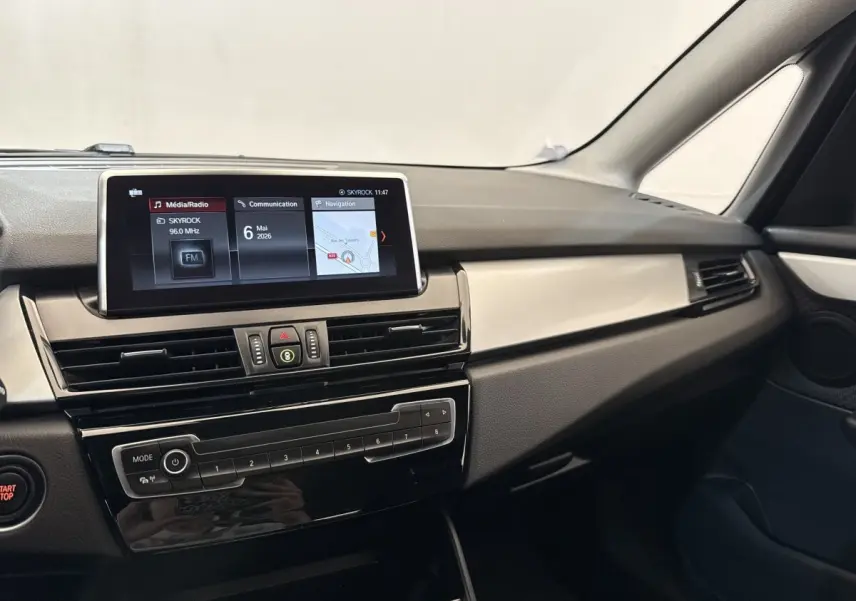 Tableau de bord intérieur de BMW Série 2 Active Tourer gris foncé, avec écran tactile et commandes centrales visibles.