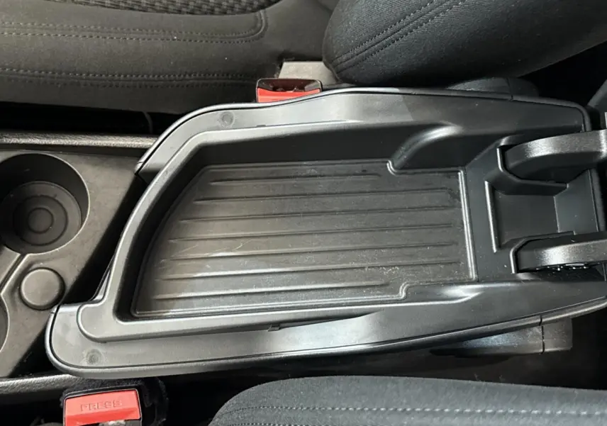 Gros plan sur la console centrale noire avec accoudoir et porte-gobelets intérieur BMW Série 2 Active Tourer 225xe.