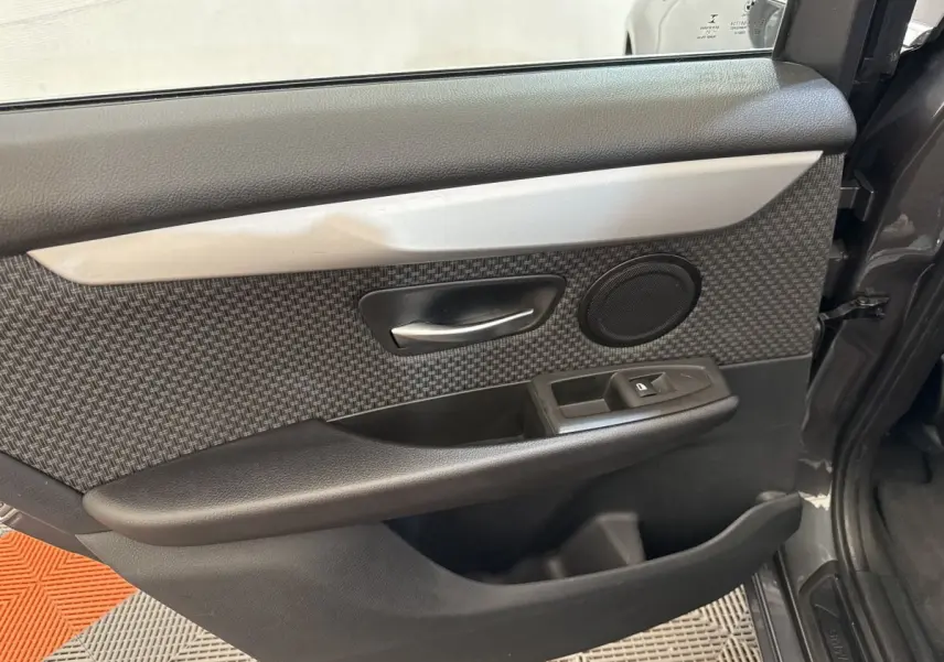 Vue rapprochée de la porte avant droite gris foncé de la BMW Série 2 Active Tourer avec habillage tissu et commandes électriques.