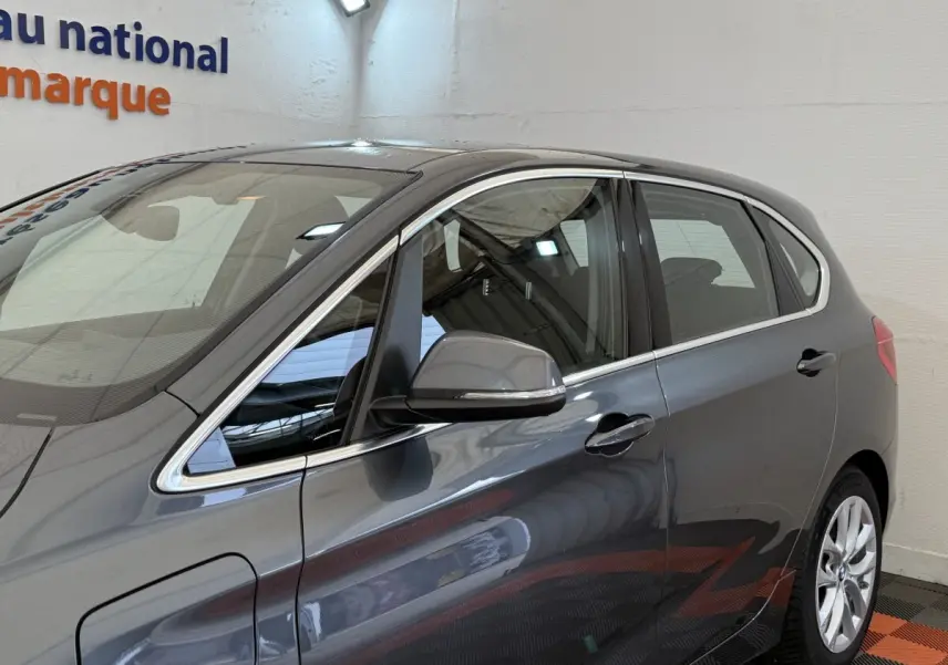 Vue latérale droite d'une BMW Série 2 Active Tourer gris foncé avec jantes alliage et rétroviseurs chromés.