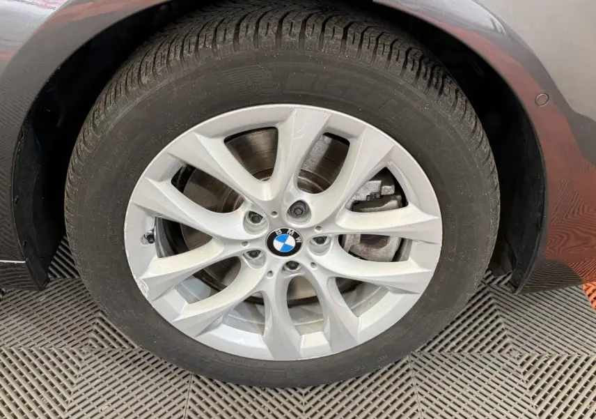 Gros plan sur la roue avant droite gris foncé d'une BMW Série 2 Active Tourer avec jante alliage à 5 doubles branches.