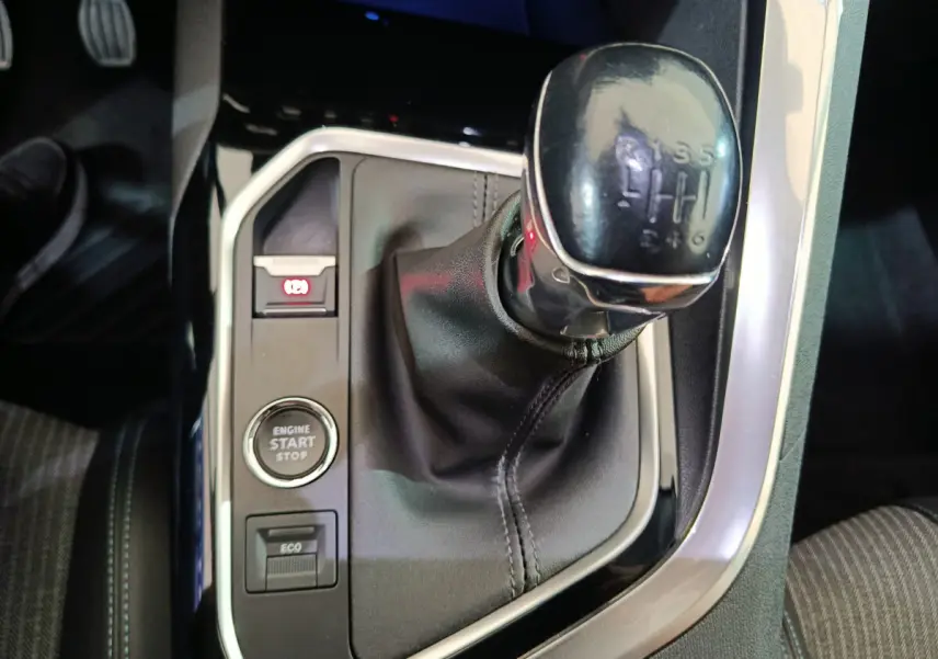 Gros plan sur la commande de boîte manuelle noire et le bouton start/stop dans l'habitacle du Peugeot 3008 bleu.