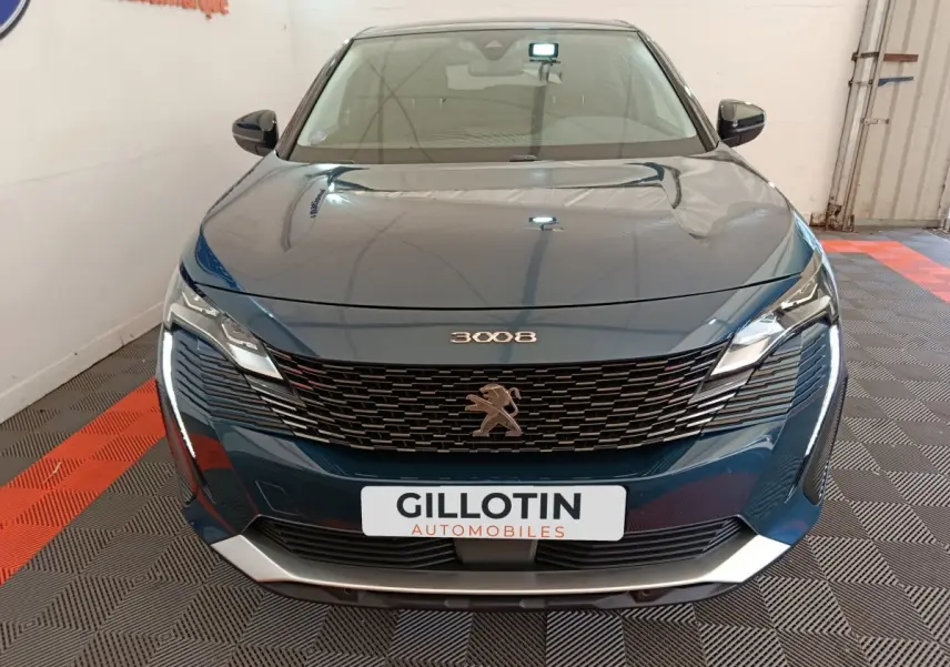 Vue frontale du Peugeot 3008 bleu 2022 avec calandre noire et phares LED distinctifs allumés.