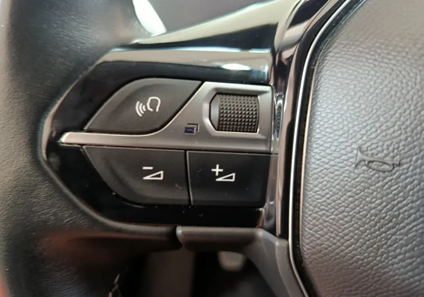 Gros plan sur les commandes gauche du volant cuir du Peugeot 3008 bleu PureTech 130 S&S Allure 2022.