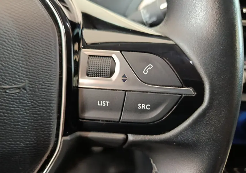 Gros plan sur les commandes gauche du volant cuir noir du Peugeot 3008 bleu, boutons appel et réglages audio visibles.
