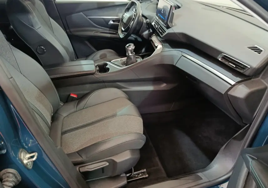Intérieur avant droit du Peugeot 3008 bleu 2022, sièges tissu-cuir et tableau de bord avec écran tactile central.