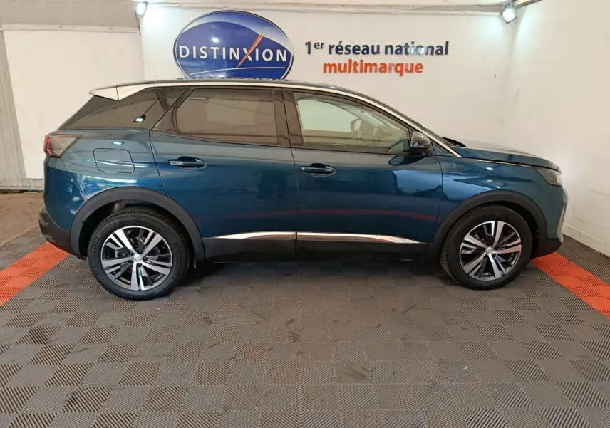 Profil côté gauche d'un Peugeot 3008 bleu 2022 garé en intérieur avec jantes alliage et vitres teintées.