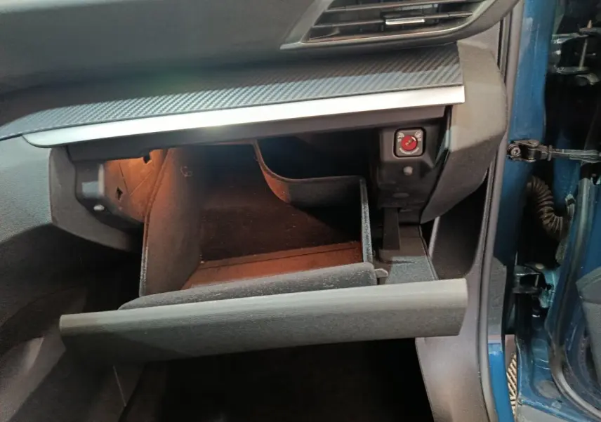 Vue intérieure côté passager du coffre à gants ouvert du Peugeot 3008 bleu 2022 avec éclairage intérieur.