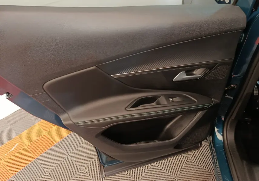 Porte avant gauche ouverte du Peugeot 3008 bleu 2022, montrant garniture noire avec surpiqûres et poignée argentée.