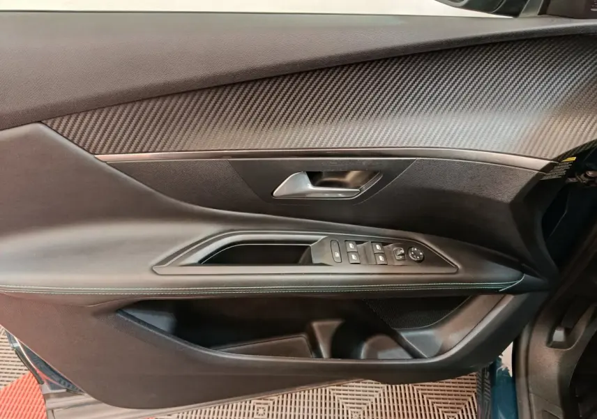 Porte côté gauche du Peugeot 3008 bleu, vue intérieure montrant les commandes des vitres et le revêtement texturé.