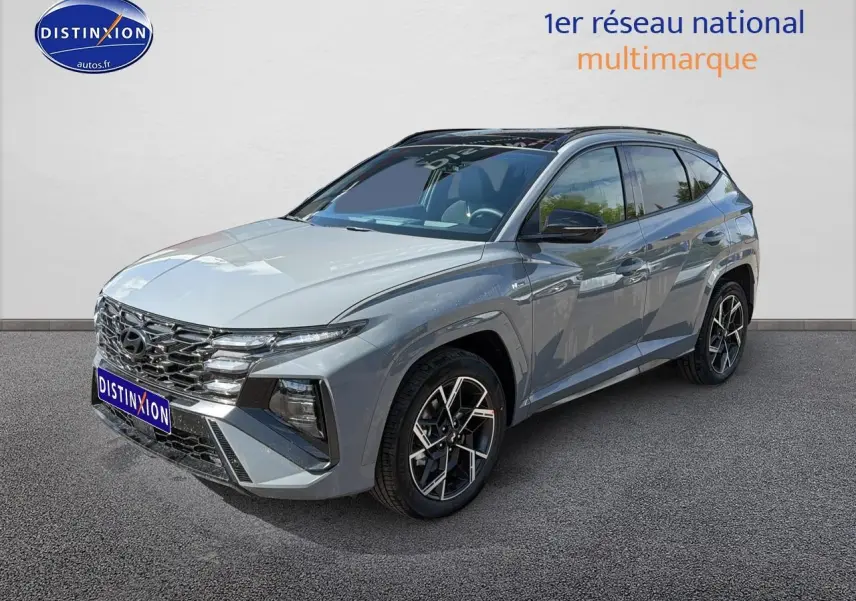 Vue 3/4 avant droite du Hyundai Tucson gris shadow avec calandre chromée et jantes alu distinctives.