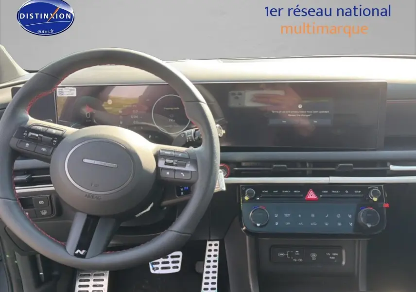 Vue intérieure centrée sur le volant cuir noir avec surpiqûres rouges du Hyundai Tucson 2026 hybride N Line Executive.