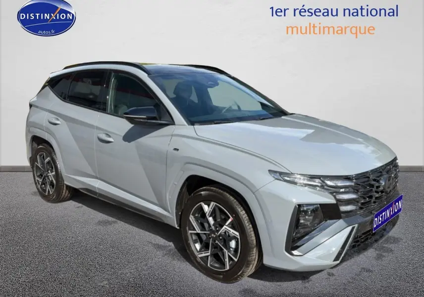 Vue 3/4 avant droite du Hyundai Tucson 2026 gris shadow avec calandre noire et jantes alu distinctives.