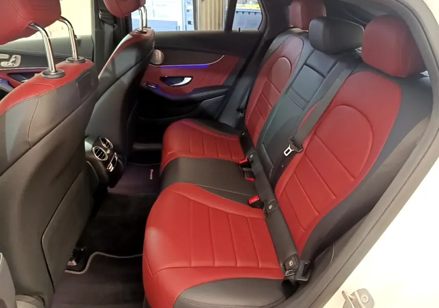 Vue intérieure arrière côté droit du Mercedes GLC 300 e AMG Line blanc, sièges en cuir bicolore rouge et noir.