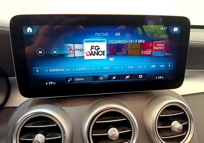 Écran tactile central affichant la radio FM dans l'habitacle du Mercedes GLC 300 e AMG Line blanc, vue intérieure.