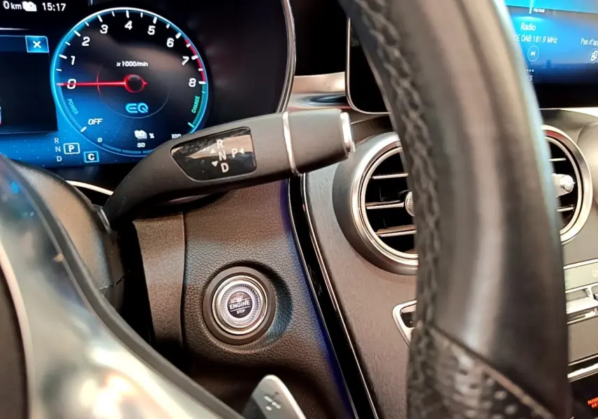 Vue intérieure rapprochée du volant cuir et du bouton démarrage du tableau de bord du Mercedes GLC Coupé blanc 2020.