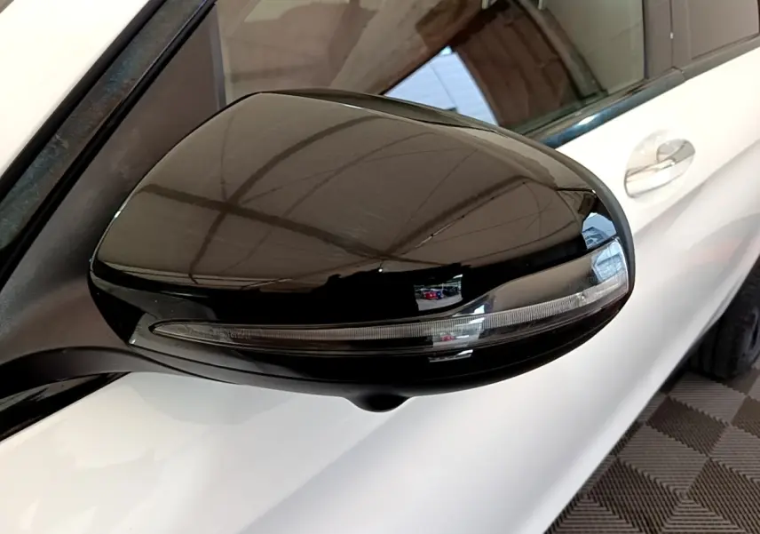 Rétroviseur droit noir brillant avec clignotant intégré sur Mercedes GLC Coupé blanc, vue rapprochée côté avant.