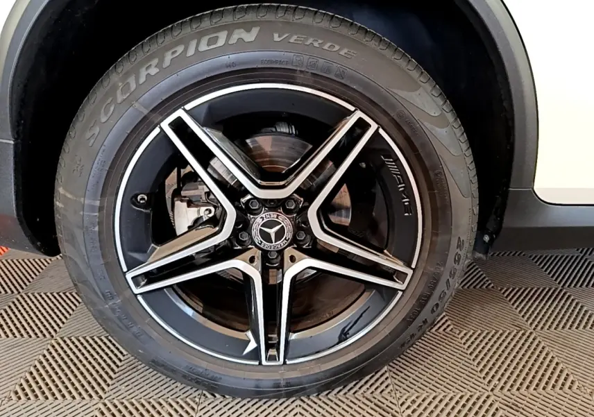 Gros plan sur la roue avant droite noire et argentée AMG du Mercedes GLC Coupé blanc hybride rechargeable.