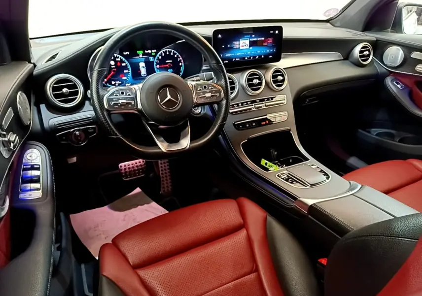 Vue intérieure avant droite du Mercedes GLC 300 e AMG Line avec sièges rouge et tableau de bord numérique.