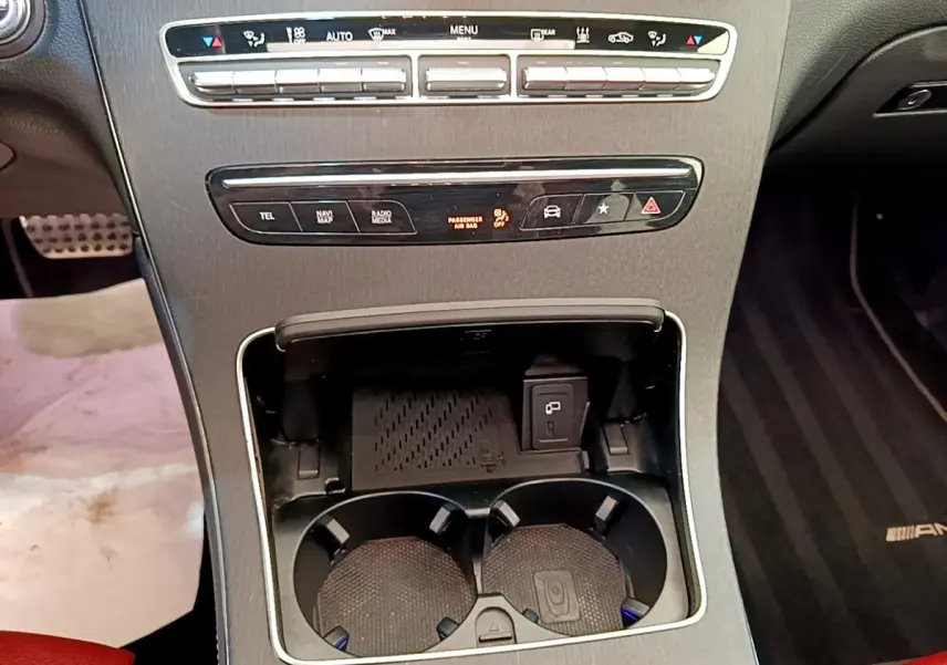 Vue rapprochée de la console centrale du Mercedes GLC 300 e AMG Line 2020, avec porte-gobelets et commandes noires.
