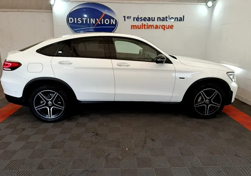 Profil côté gauche d'un Mercedes GLC Coupé blanc 2020 AMG Line avec jantes noires et toit incliné.
