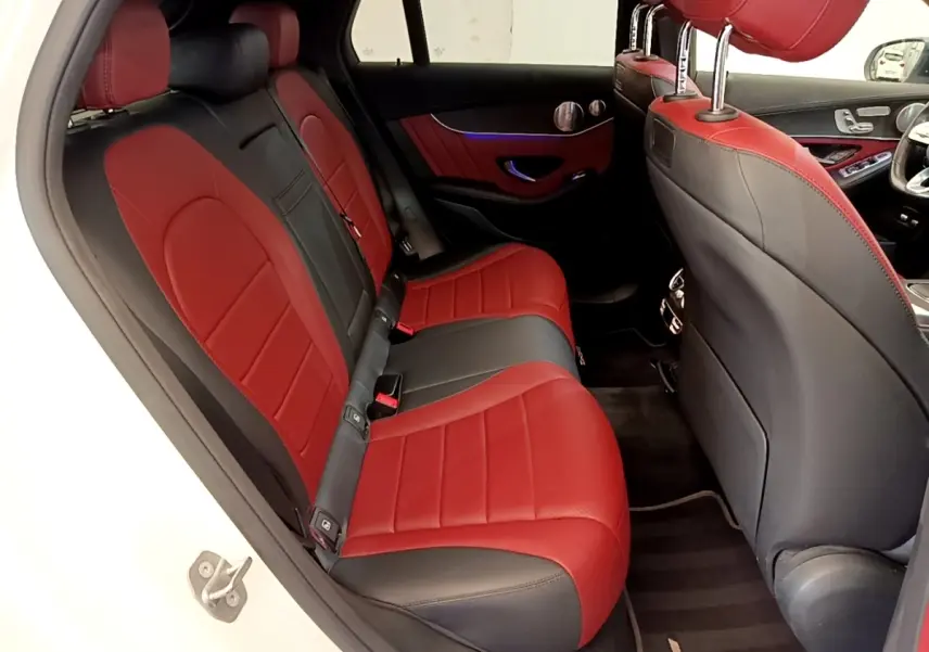 Vue intérieure arrière droite du Mercedes GLC 300 e AMG Line blanc, sièges cuir bicolores rouge et noir.
